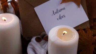 AUTUMN VİBESİ Tebrik kartı konsepti Pencere kenarındaki rahat evde sonbahar tatilini kutluyor Hygge estetik atmosferi sonbahar yaprakları, baharatlar ve mum örgü örülmüş beyaz süveter