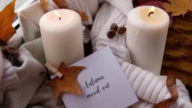 AUTUMN Kart Konsepti 'nde AUTUMN Tebrik kartı Konsepti Pencere kenarındaki rahat evde sonbahar tatilini kutluyor Hygge estetik atmosferi Sonbahar yaprakları, baharatlar ve mum örgü örülmüş beyaz süveter
