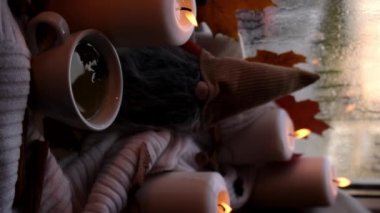 Dikey görüntüler Şükran Günü ve Hello Fall Cadılar Bayramı konsepti pencere kenarındaki rahat evde sonbahar tatilini kutluyor Hygge estetik atmosferi sonbahar yaprakları, baharatlar ve örgü örülmüş mum.