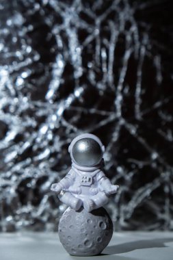 Plastic toy figure astronaut on silver background Copy space. Concept of out of earth travel, private spaceman commercial flights. Space missions and Sustainability