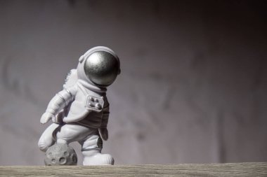 Plastic toy figure astronaut on moon concrete background Copy space. Concept of out of earth travel, private spaceman commercial flights. Space missions and Sustainability
