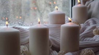 Sonbahar tatili konsepti. Pencere kenarındaki Hygge estetik atmosferinde örgü örülmüş beyaz süveterin üzerinde rahat bir evde. Mikro anın sakin yaşamı yavaş yavaş yaşanır. Ruhsal sağlık.