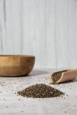 Tahta kaşıkla bir yığın Chia tohumu. Omega 3 yağ asitleri bakımından zengin sağlıklı süper yiyecekler. Kuru, sağlıklı, doğal bileşen. Chia taneleri düşüyor. Vejetaryen yemeği. 