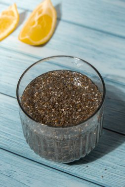 Preparing superfood water drink rich in Omega 3 fatty acids. Pouring coconut water. Adding soaked chia seeds and lemon detox Breakfast. Clean eating, weight loss, dieting food concept Vegetarian