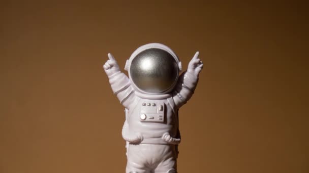 放大塑料玩具形象宇航员米色中性背景复制空间 走出地球旅行的概念 私人航天人商业飞行 空间飞行任务与可持续性 — 图库视频影像