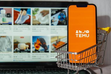 Gdansk, Polonya - Mart 2023 Temu uygulama simgesi MacBook Apple bilgisayar dizüstü bilgisayarı ve alışveriş arabalı cep telefonu ekranında. Çin merkezli Pinduoduo e-ticaret platformunun Temu yan kuruluşu. İnternetten alışveriş