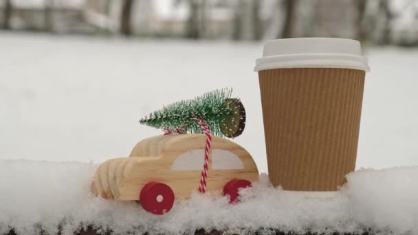 Drewniany Samochód Niosący Choinkę Śniegu Obok Recyklingu Eko Papierowej Kawy — Wideo stockowe