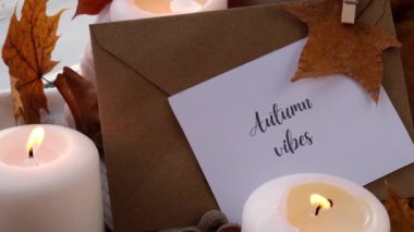 AUTUMN VİBESİ Tebrik kartı konsepti Pencere kenarındaki rahat evde sonbahar tatilini kutluyor Hygge estetik atmosferi sonbahar yaprakları, baharatlar ve mum örgü örülmüş beyaz süveter