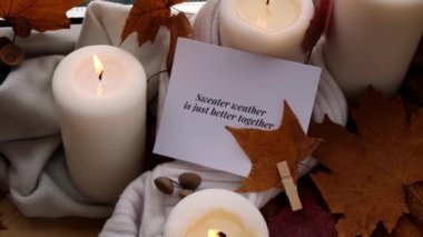 Sweater Weather, birlikte daha iyi bir tebrik kartı konseptidir. Pencere kenarındaki Hygge estetik evinde sonbahar tatilini kutlamak sonbahar yaprakları, baharatlar ve örgü örülmüş mumlar.