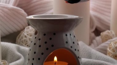 Aroma lambası, gerekli yağ, aromaterapi evde, yanan mum, gerekli yağ damlaları. Evde rahatlama ve stres önleme kavramı. Doğal Spa Tedavisi. Konforlu bir evde ev bakımı.