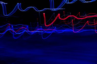 Long exposure, light painting photography, multi color swirl effect against black background. Night city lights. Creative background wallpaper