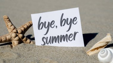 Elveda, deniz yıldızı deniz kabuğu yaz tatili dekorunun arka planında kağıt tebrik kartı üzerine yazılmış bir yazı. Kumsalın güneş kıyısı. Tatil konsepti kartpostalı. Kaçmak Seyahat İş Konsepti