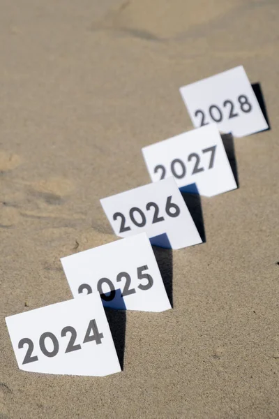 Üst üste 2024 'ten 2028' e kadar geçen yılların sayılı kağıtları. Yeni yıla başlama konsepti. Çözünürlük zamanı uçuş planı amaç motivasyon geri sayımıdır