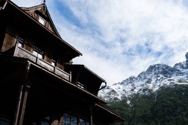 Karlı dağlardaki eski ahşap ev, Zakopane Polonya 'daki yeşil ormanlar. Dağ doğa manzarası. Mavi gökyüzü. Doğal yeşil turizm konseptiyle seyahat edin. Yürüyüş refahı 