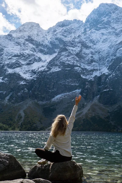 Young woman enjoying nature in Morskie Oko Snowy Mountain Hut in Polish Tatry mountains Zakopane Poland. Naturecore aesthetic beautiful green hills. Mental and physical wellbeing Travel outdoors