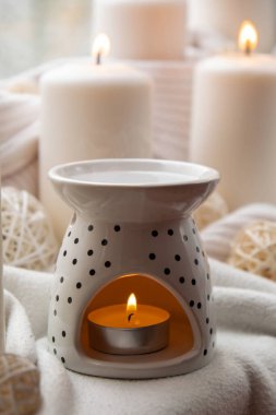 Aroma lambası, gerekli yağ, aromaterapi evde, yanan mum, gerekli yağ damlaları. Evde rahatlama ve stres önleme kavramı. Doğal Spa Tedavisi. Konforlu bir evde ev bakımı.