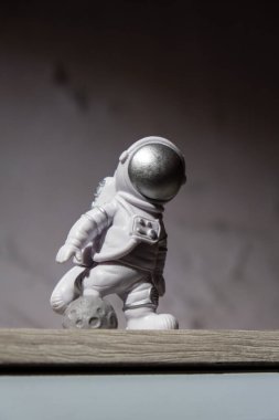 Plastic toy figure astronaut on moon concrete background Copy space. Concept of out of earth travel, private spaceman commercial flights. Space missions and Sustainability