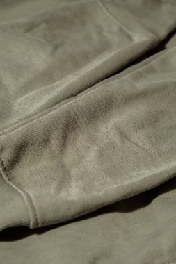 Yeşil kazağın ipleri. Temizlik ve pamuk ipliği toplamadan önce. Yakın çekim haplı giysiler. Eski kullanılmış pamuklu giysiler. Hasarlı eski bakımların restorasyonu. Kumaş tekstil onarımı