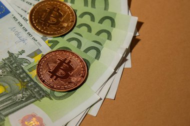 Bitcoin gold coin on bills of 100 euros eu currency. Bitcoin mining trading concept. BTC golden money. Worldwide virtual internet Cryptocurrency or crypto digital payment system. Digital coin money