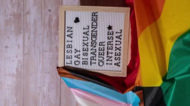İpek malzemeden yapılmış Gökkuşağı LGBTQIA bayrağındaki LGBTQIA tanımlama çerçevesine düşey yakınlaştır. Lezbiyen, eşcinsel, biseksüel, trans, ibne, interseksüel, aseksüel. LGBTQ gurur ayının sembolü. Eşit haklar