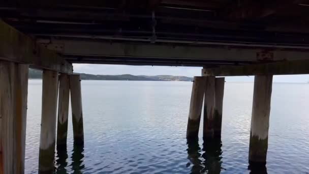 海の桟橋の下にある海水 橋の下から見える小さな波の海 情熱の激しい海での孤独と人生への反射の概念 — ストック動画