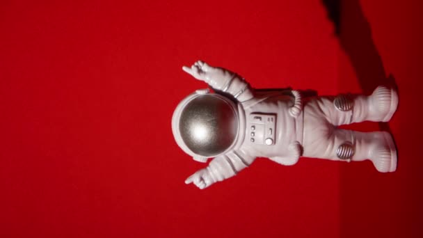 垂直放大塑料玩具宇航员在彩色红色背景复制空间 走出地球旅行的概念 私人航天人商业飞行 空间飞行任务与可持续性 — 图库视频影像