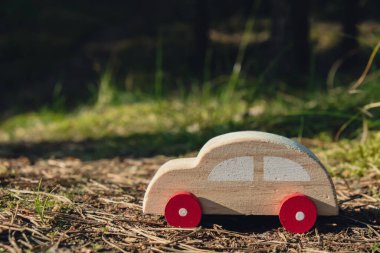 Yeşil orman arka planında tahta oyuncak araba. Eko-araba konsepti dünya arabaları ücretsiz elektrikli araç çevresi otomobil taşıma elektrikli araç. Melez elektrik. Sürdürülebilir motor. CO2 sıfır