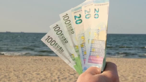 砂浜の海岸線に現金ユーロ請求の広がりを表示する認識できない女性 休暇のために節約するコンセプトファイナンス 旅行の休日のコスト 余分なお金 受動的な収入 — ストック動画