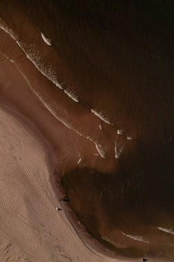 Dalgaların, deniz kıyılarının insansız hava görüntüsü. Kumsallar ve kumullar, sakin deniz dalgaları insansız hava aracıyla ele geçirilen doğa manzarası. Polonya 'da turizm