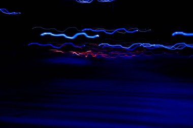 Long exposure, light painting photography, multi color swirl effect against black background. Night city lights. Creative background wallpaper