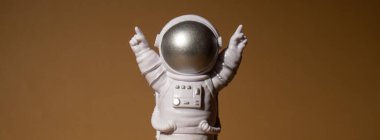Plastic toy figure astronaut on beige neutral background Copy space. Concept of out of earth travel, private spaceman commercial flights. Space missions and Sustainability