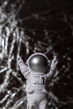 Plastic toy figure astronaut on silver background Copy space. Concept of out of earth travel, private spaceman commercial flights. Space missions and Sustainability