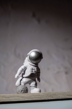 Plastic toy figure astronaut on moon concrete background Copy space. Concept of out of earth travel, private spaceman commercial flights. Space missions and Sustainability