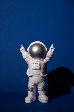 Renkli mavi arkaplan fotokopi uzayındaki plastik oyuncak astronot. Dünya dışı seyahat kavramı, özel uzay adamı ticari uçuşları. Uzay görevleri ve Sürdürülebilirlik