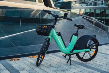 Polonya şehir merkezindeki iş merkezinin yakınına park edilmiş kiralık elektrikli bisiklet. Kentsel çevrede bisiklet paylaşım servisi var. E-scooter elektrikli scooter kiraladı. Ekolojik hareketlilik