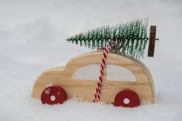Holzauto Trägt Weihnachtsbaum Über Schnee Kopierplatz Für Text Spielzeugauto Verschneiter — Stockfoto