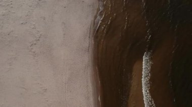 Dalgaların, deniz kıyılarının insansız hava görüntüsü. Kumsallar ve kumullar, sakin deniz dalgaları insansız hava aracıyla ele geçirilen doğa manzarası. Polonya 'da turizm