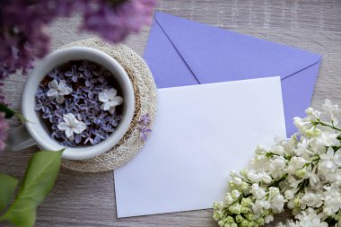 Boş zarf kağıdının fotokopisini çek. Beyaz bardakta siyah çay ve aromatik leylak çiçekleri olsun. Bahar kompozisyonu bir fincan leylak çayı içerken mor leylak dalları çiçek açar.