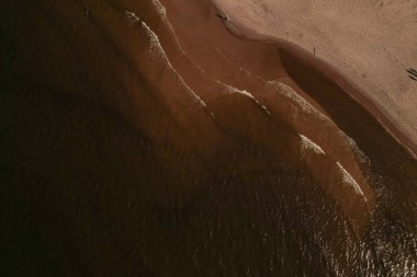 Dalgaların, deniz kıyılarının insansız hava görüntüsü. Kumsallar ve kumullar, sakin deniz dalgaları insansız hava aracıyla ele geçirilen doğa manzarası. Polonya 'da turizm