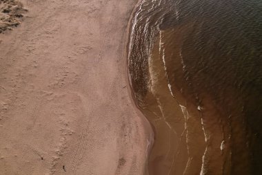 Dalgaların, deniz kıyılarının insansız hava görüntüsü. Kumsallar ve kumullar, sakin deniz dalgaları insansız hava aracıyla ele geçirilen doğa manzarası. Polonya 'da turizm