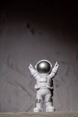 Plastic toy figure astronaut on moon concrete background Copy space. Concept of out of earth travel, private spaceman commercial flights. Space missions and Sustainability