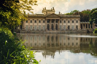 Baths classicist Palace on the Isle in Lazienki Park touristic place in Warsaw. Lazienki Royal Baths Park, Warsaw Poland. Mirror Reflection on the Lake. Nature in summer Baroque columns 