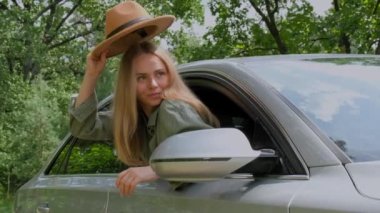 Şapkalı sarışın kadın kafasını ön camdan dışarı çıkartıyor. Genç turistler yerel seyahatleri keşfederek samimi anlar yaşarlar. Yavaş çekim Uzaklaşmanın gerçek duyguları ve rahatlamak açık havada