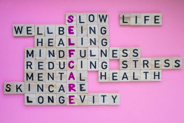 Top view of SELFCARE word on pink background. Minimalism creative crossword puzzle concept. Message of text Slow life wellbeing healing mindfulness reducing stress mental health skincare longevity clipart