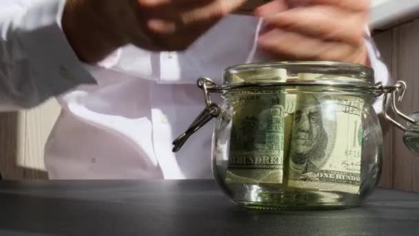 男人们从储蓄罐里的玻璃瓶里数着钱的钞票 然后数着它们 不明不白的商人缩手缩脚 节约预算投资的概念 — 图库视频影像