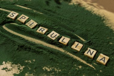 SPIRULINA deniz yosunlarının yeşil arka planında klorella harfi. Organik mavi-yeşil alg spirulina tozu. Doğal ilacın sağlıklı faydaları. Alternatif ilaç mineral gıda antioksidan