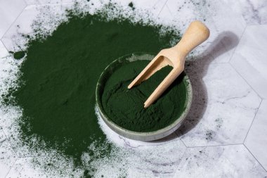 Mavi-yeşil yosun klorella ve tahta kaşıkla kasede spirulina tozu. Süper toz. Doğal alg takviyesi. Detoks süper yiyecek içeceği kokteyli. Besin takviyesi protein ve beta