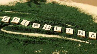 SPIRULINA deniz yosunlarının yeşil arka planında klorella harfi. Organik mavi-yeşil alg spirulina tozu. Doğal ilacın sağlıklı faydaları. Alternatif ilaç mineral gıda antioksidan