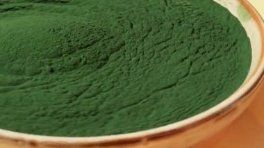 Dönen organik mavi-yeşil yosun tabaktaki spirulina tozu. Spiulina Klorella 'nın sağlık yararları. Diyet için vitamin ve mineraller. Detox diyet takviyesi. Deniz yosunu süper yiyecek kavramı.