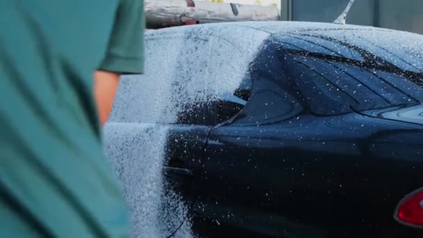 タッチレスの洗車で豪華な黒い車を洗浄する 車の詳細をクリーニングします 泡のセルフサービスおよび高圧水が付いている洗浄セダン車 都市環境における清潔さと秩序 — ストック動画
